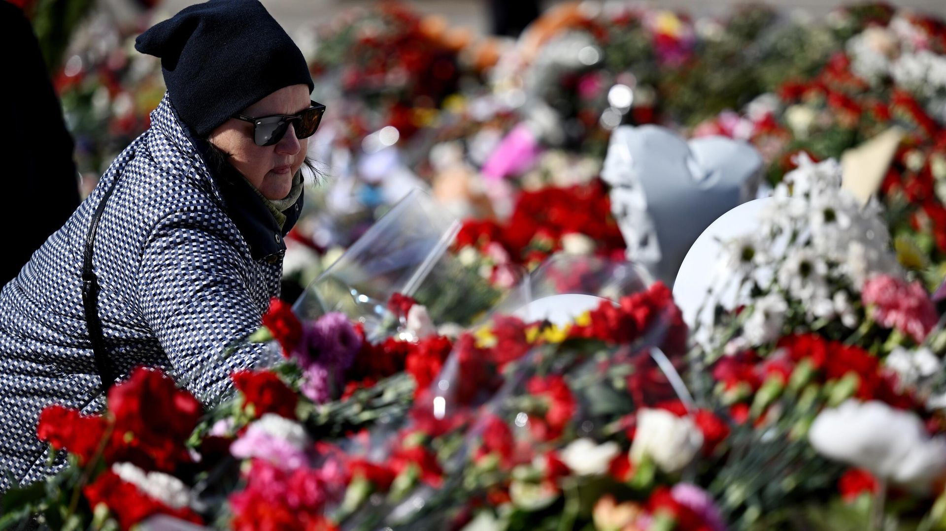 Женщина возлагает цветы к стихийному мемориалу возле подмосковного Крокус Сити Холла - ПРАЙМ, 1920, 27.03.2024