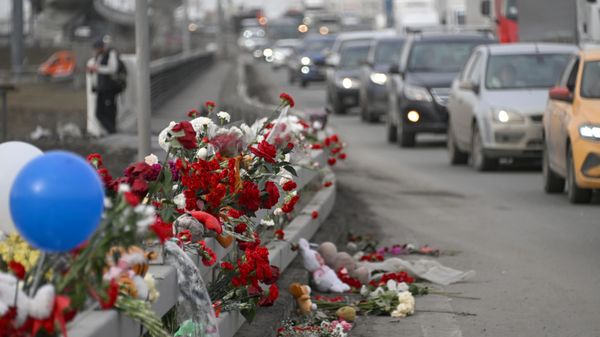 Цветы у стихийного мемориала вдоль дороги у здания концертного зала Крокус Сити Холл