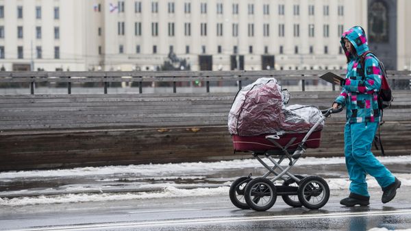 Женщина гуляет с ребенком в коляске