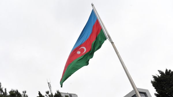 Государственный флаг Азербайджана на фоне здания Национального собрания Азербайджана в Баку