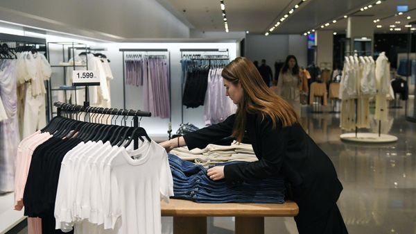 Продавец раскладывает одежду в магазине 
