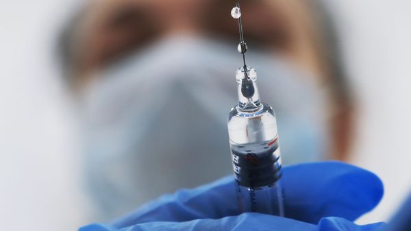 Медик готовит шприц с вакциной Медик готовит шприц с вакциной
