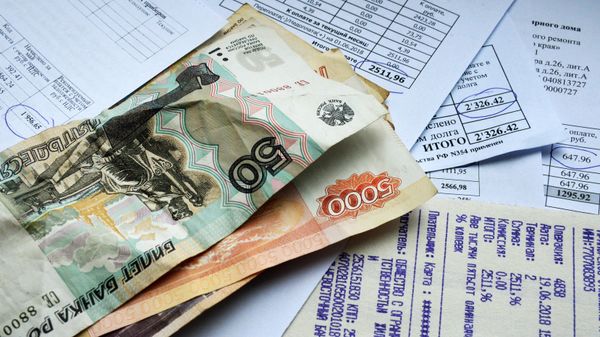 Денежные купюры и квитанции за оплату коммунальных услуг