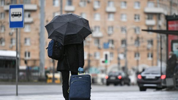 Пассажир стоит возле остановки общественного транспорта на Комсомольской площади в Москве