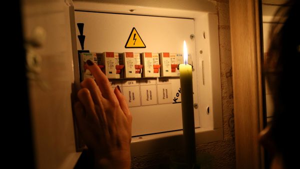 Девушка у электрического щитка в своей квартире во время тестового отключения электричества в Киеве
