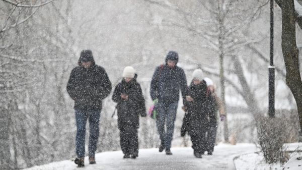 Прохожие на улице во время снегопада в Москве