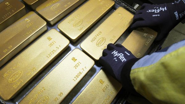 Сотрудник укладывает на тележку маркированные слитки золота высшей пробы