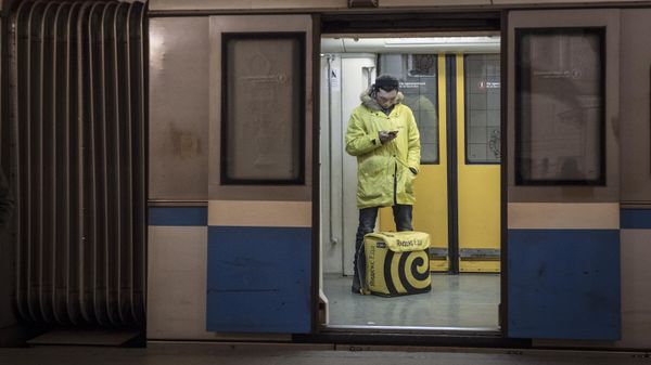 Курьер сервиса доставки еды в вагоне Московского метрополитена