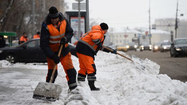Сотрудники коммунальных служб убирают снег на улице