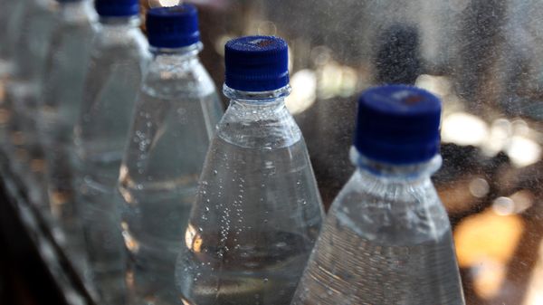 Бутылки с минеральной водой на транспортировочной ленте Бутылки с минеральной водой на транспортировочной ленте