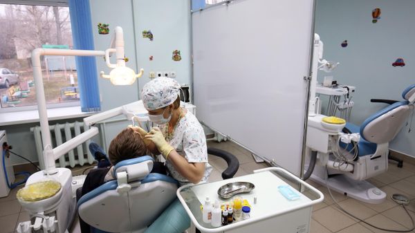 Стоматолог во время приема пациента в стоматологической поликлинике