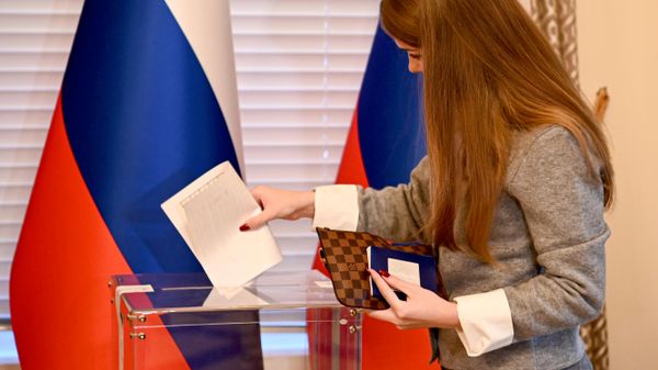 Женщина принимает участие в голосовании на выборах депутатов Государственной Думы РФ девятого созыва на избирательном участке генерального консульства России в Нью-Йорке