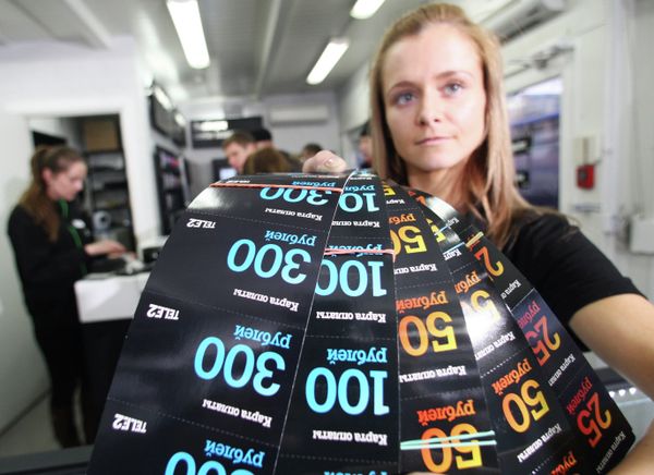 Сотрудник салона сотовой связи TELE2 показывает карты оплаты Сотрудник салона сотовой связи TELE2 показывает карты оплаты