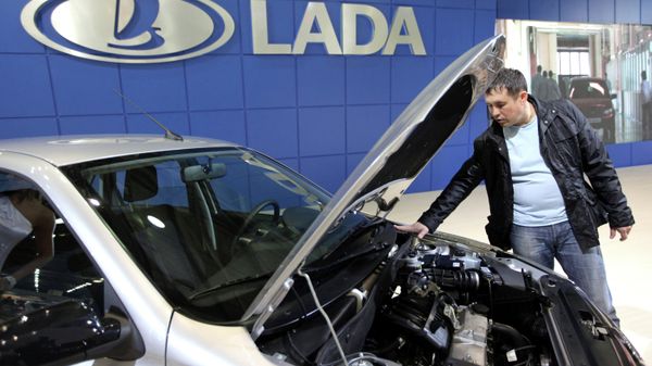 #Посетитель осматривает автомобиль Lada Granta