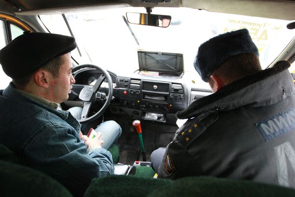 Сотрудник ДПС проводит проверку документов у водителя маршрутки