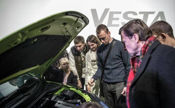 Посетители осматривают моторный отсек автомобиля Lada Vesta после начала продаж в Москве Посетители осматривают моторный отсек автомобиля Lada Vesta после начала продаж в Москве