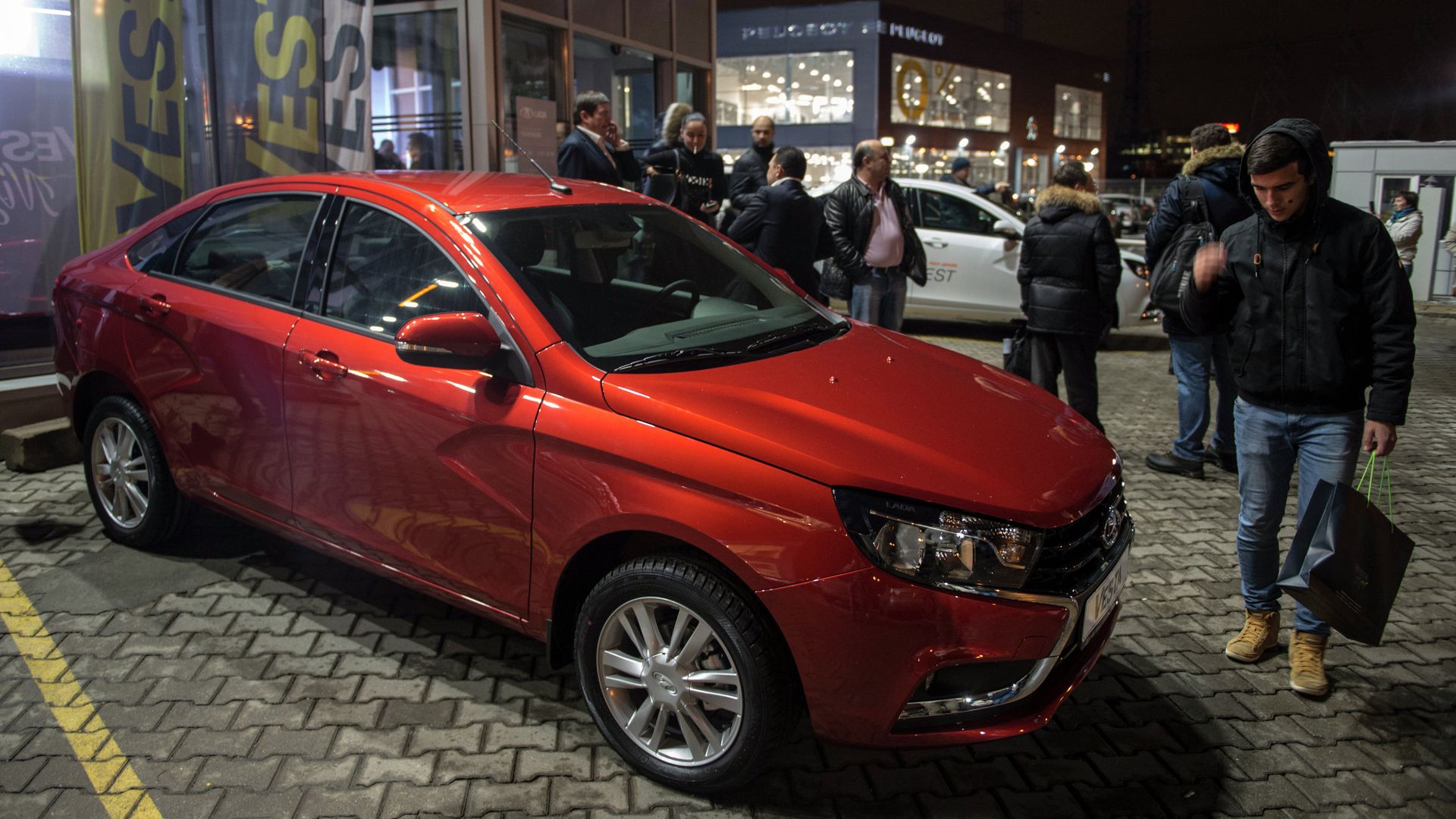 *Молодые люди осматривают автомобиль Lada Vesta после начала продаж в Москве - ПРАЙМ, 1920, 02.07.2025