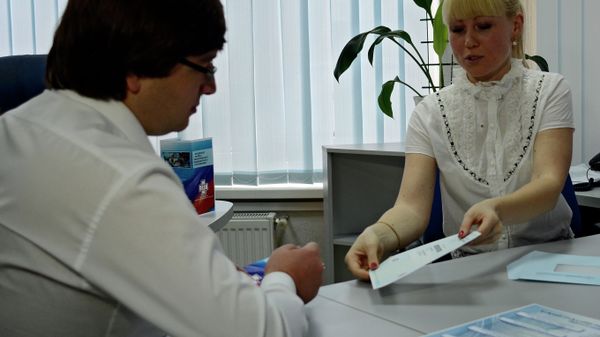 Сотрудница Федерального фонда обязательного медицинского страхования (ФФОМС) оформляет полис ОМС в Симферополе