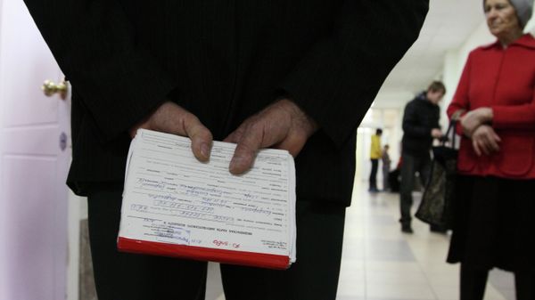 Мужчина держит в руках медицинскую карточку