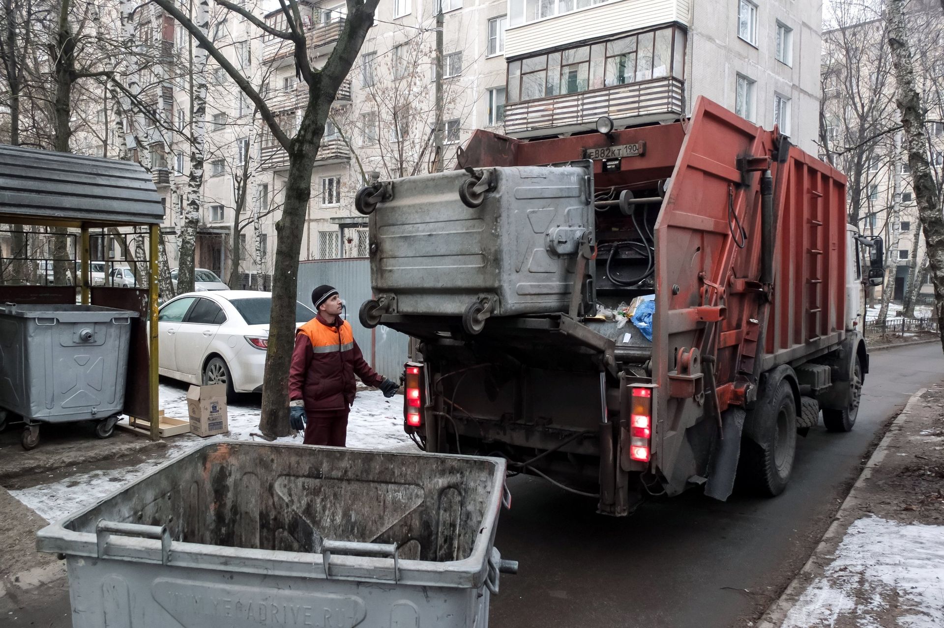 Сотрудник коммунальных служб выгружает мусор из контейнера в мусоровоз. ЖКХ Сотрудник коммунальных служб выгружает мусор из контейнера в мусоровоз. ЖКХ - ПРАЙМ, 1920, 20.02.2022