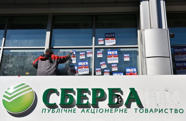 #Рабочий очищает фасад центрального отделения дочернего предприятия Сбербанка России в Киеве от листовок