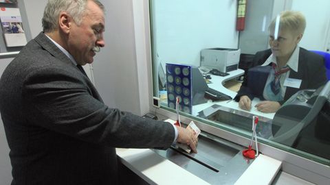 #Кассир выдает деньги клиенту операционного зала отделения банка ВТБ-24 на Мясницкой улице