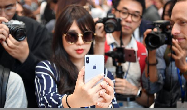 Девушка тестирует новый iPhone X в штаб-квартире Apple в Купертино Девушка тестирует новый iPhone X в штаб-квартире Apple в Купертино