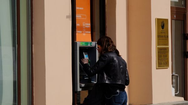 Девушка у банкомата Сбербанка.