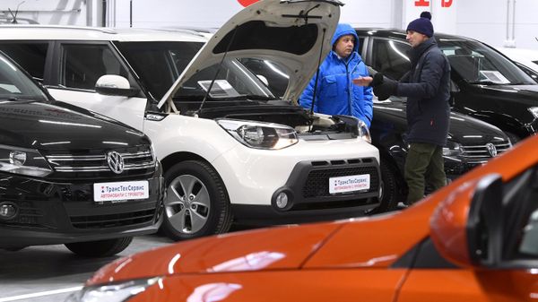 Покупатель осматривает машину в автосалоне