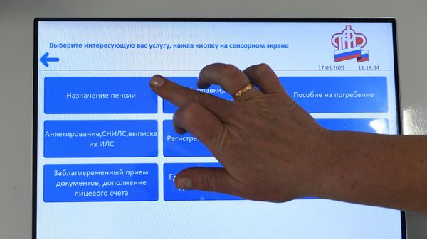 Человек выбирает услугу в терминале в ПФР в Москве.