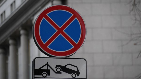Дорожные знаки Остановка запрещена и Работает эвакуатор на одной из улиц в Москве