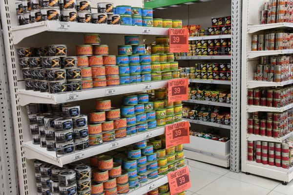 Полки с рыбными консервами в супермаркете