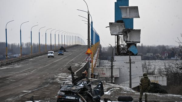 Разрушенный автомобиль у моста через реку Днепр в окрестностях Херсона.