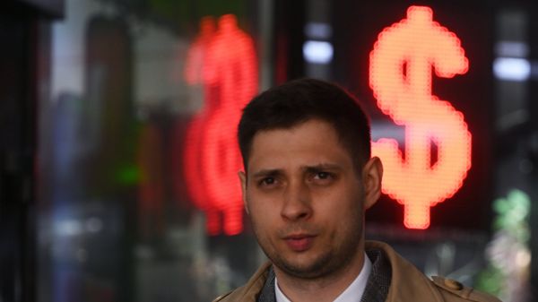 Мужчина проходит мимо пункта обмена валют в Москве